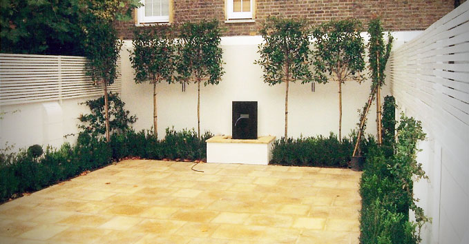 A terrace garden with trees around the edge and a fountain